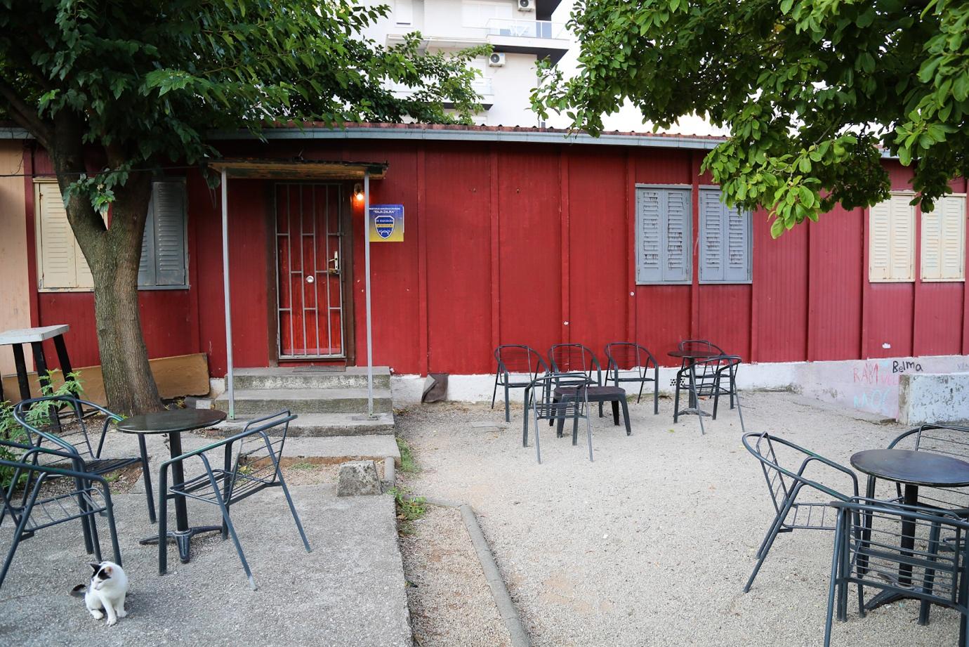A red building with chairs and tables

Description automatically generated