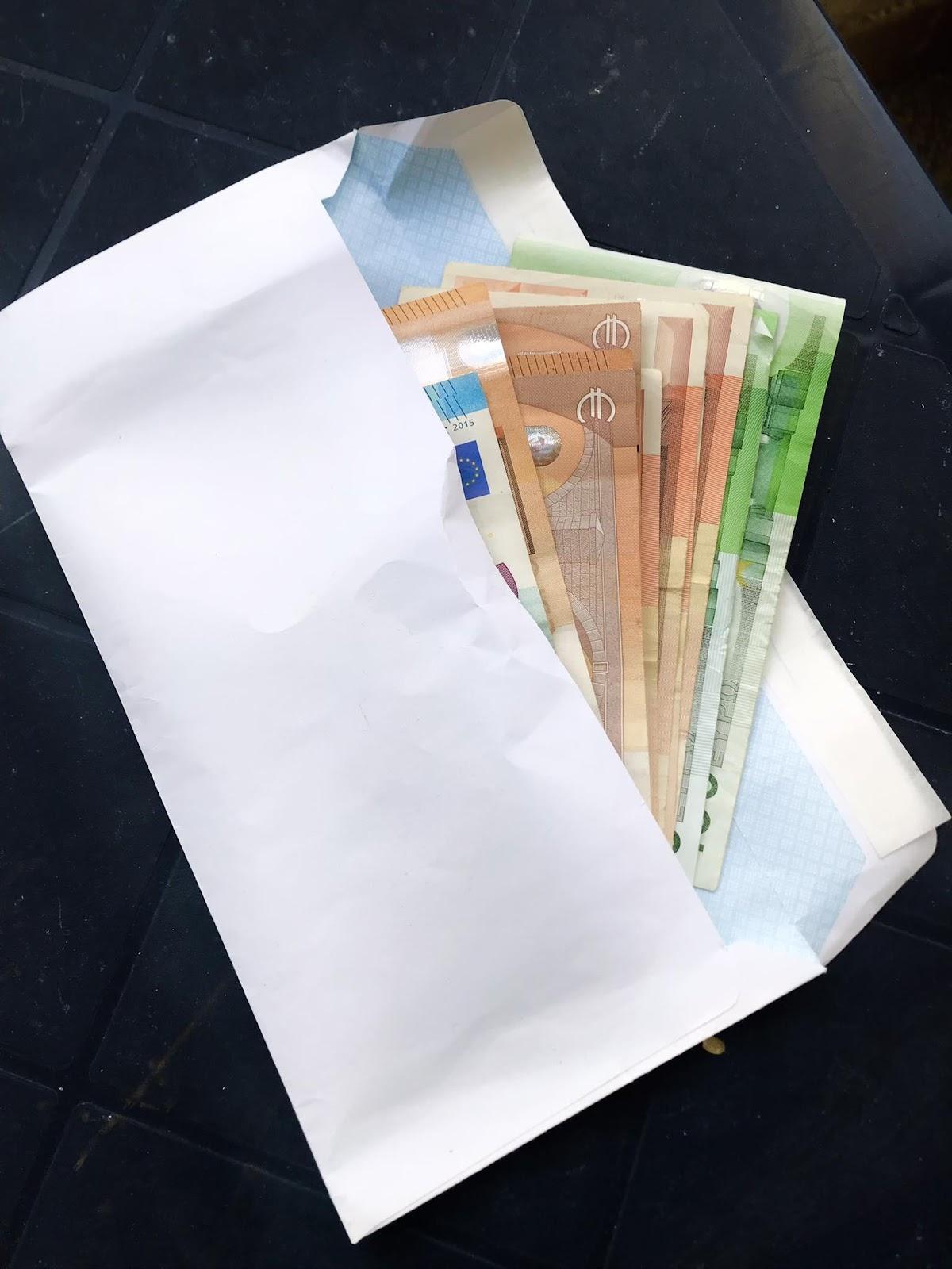 A white envelope with money in it

Description automatically generated
