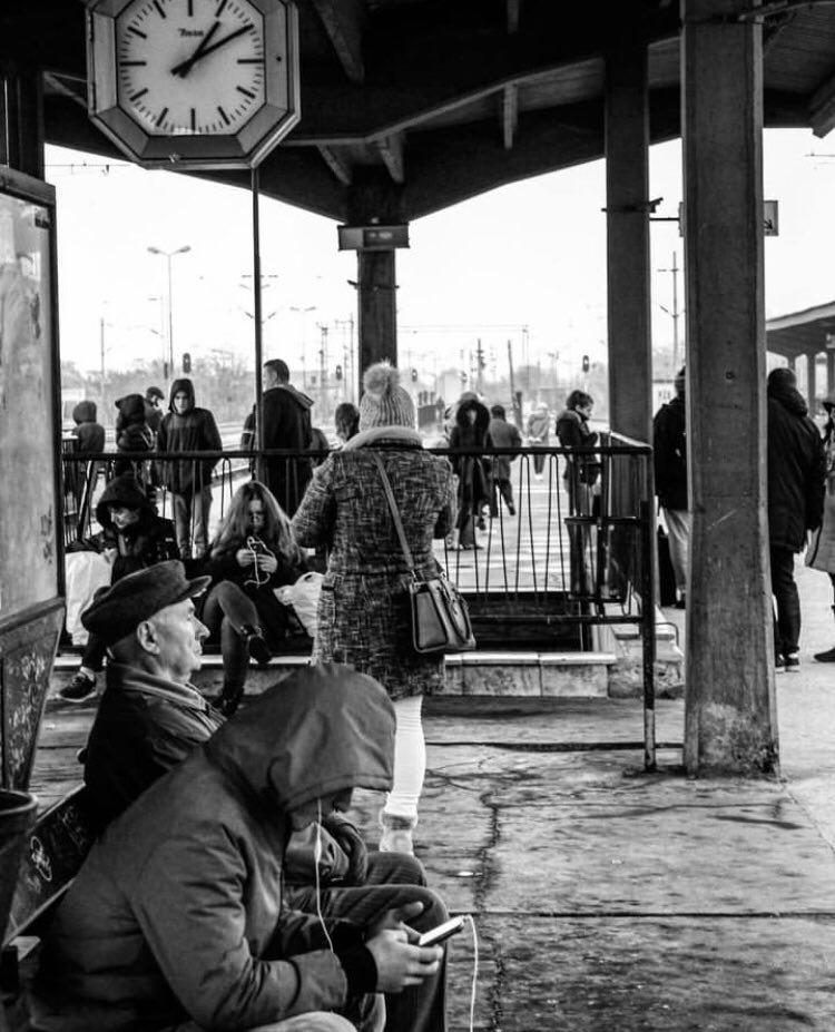 A group of people waiting at a bus stop

Description automatically generated