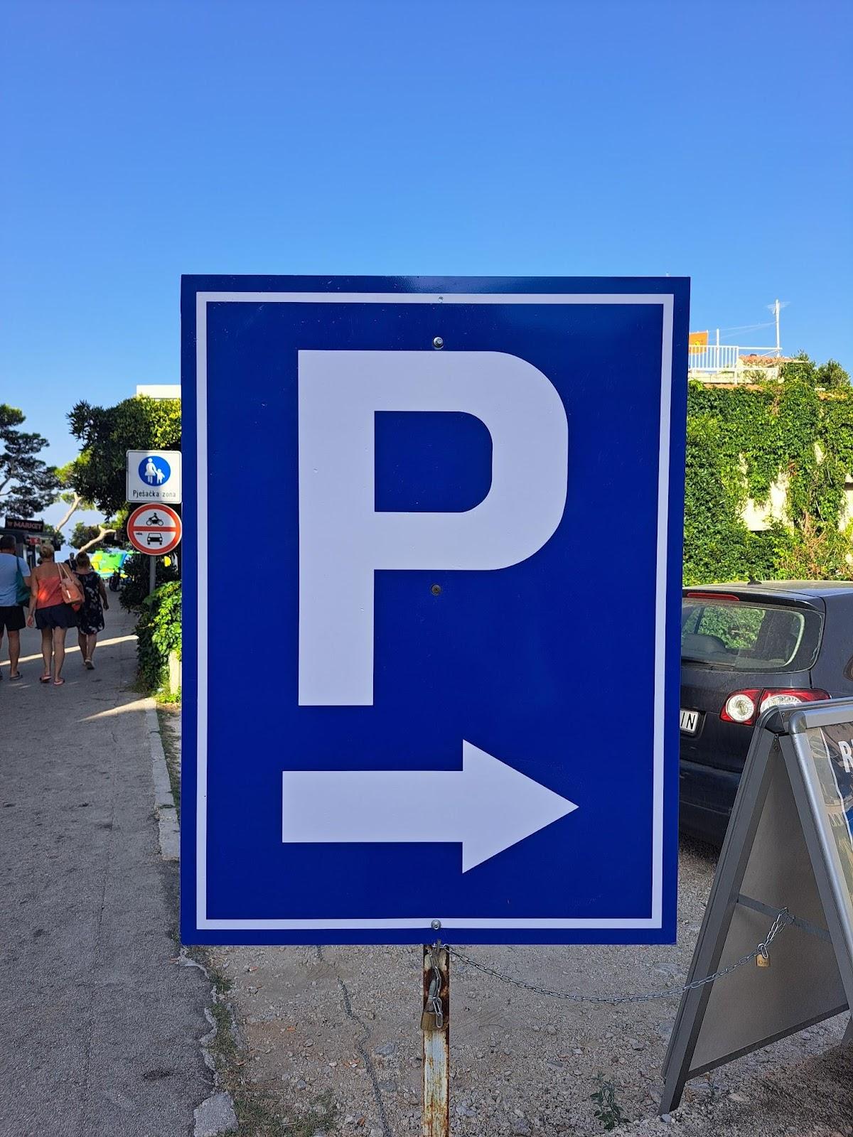 A blue sign with a white p and arrow

Description automatically generated